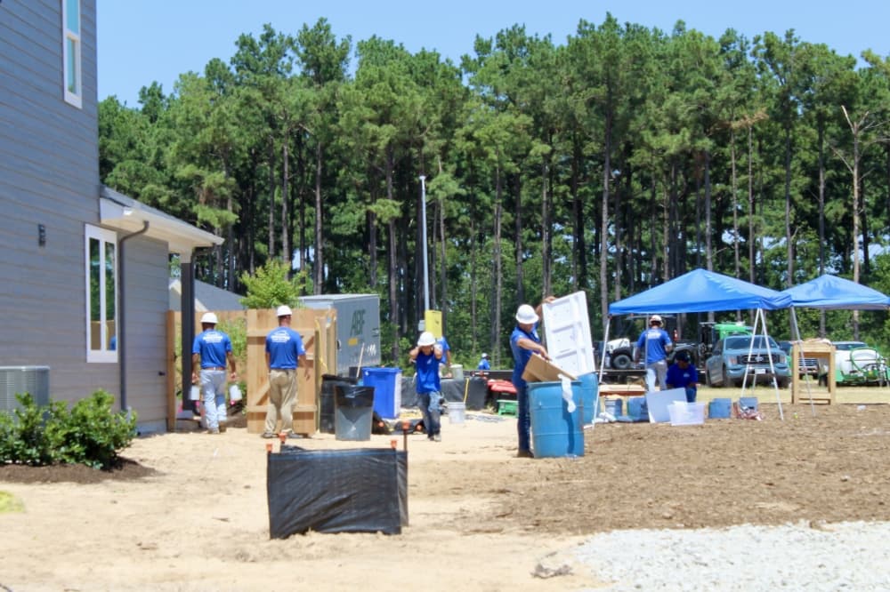 volunteers working on side of the house