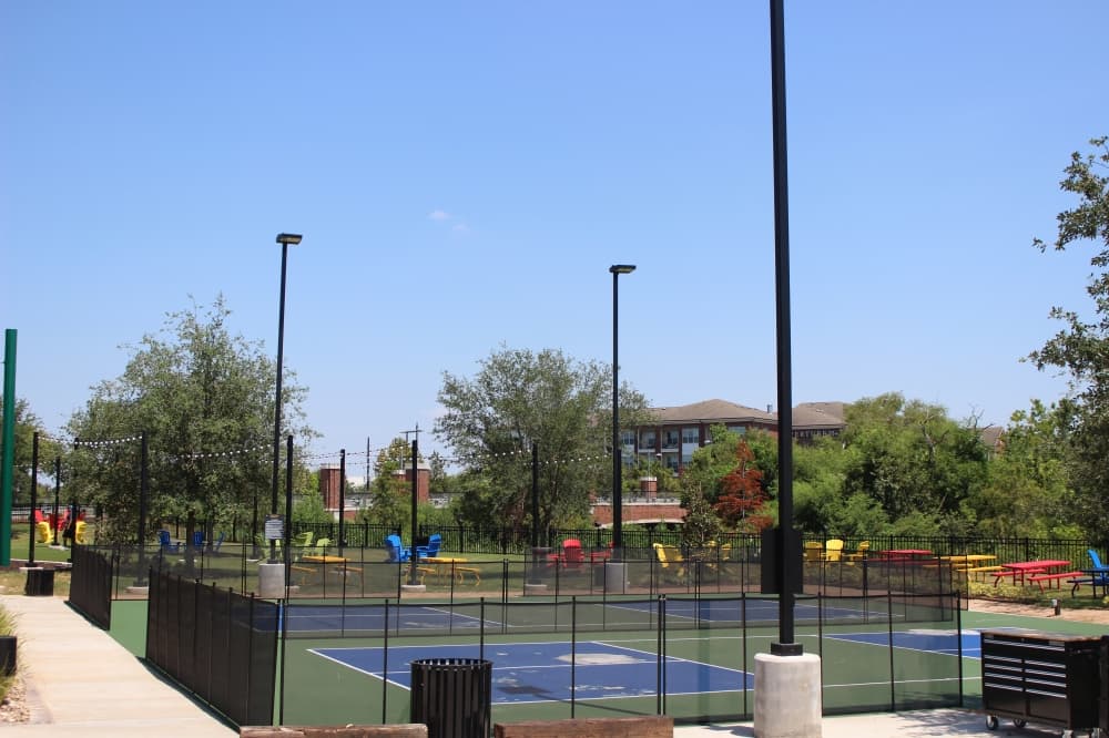 A stage with a projector, pickleball courts, a bar, a playground and ample seating occupy the grounds. (Asia Armour/Community Impact)