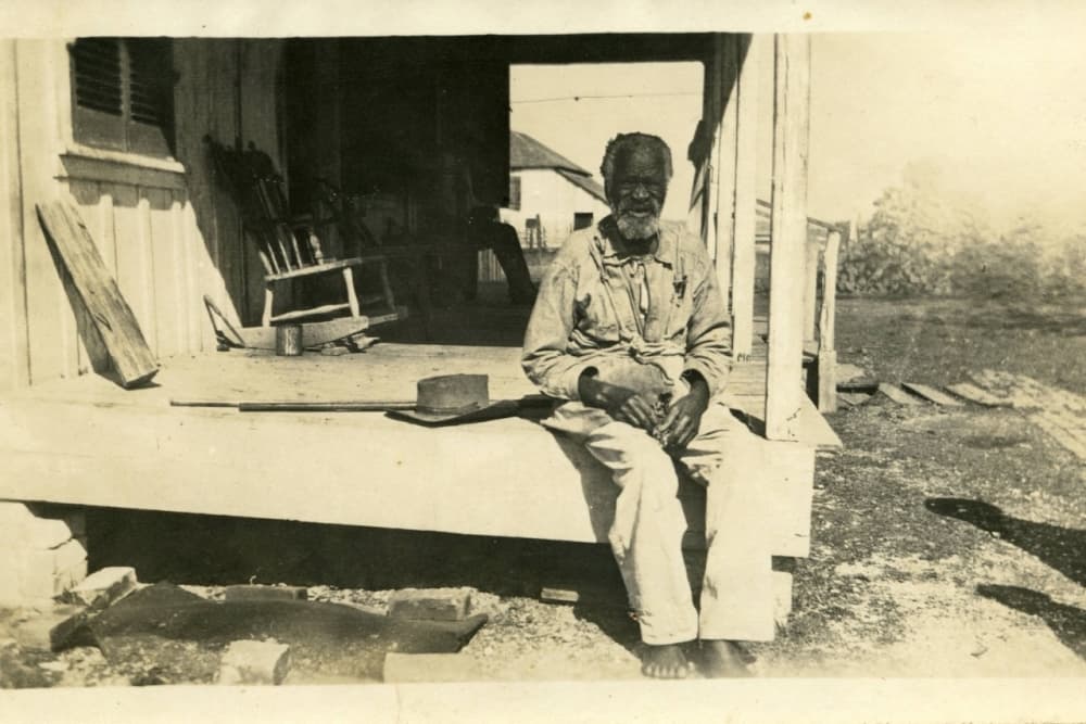 An unknown African American male sitting on a porch in Poor Farm.