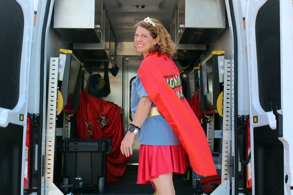 Female walking into a van wearing superhero costume. 