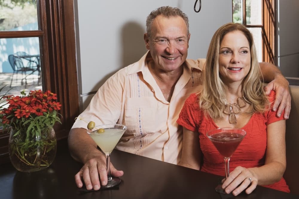 A husband and wife post in a restaurant. 