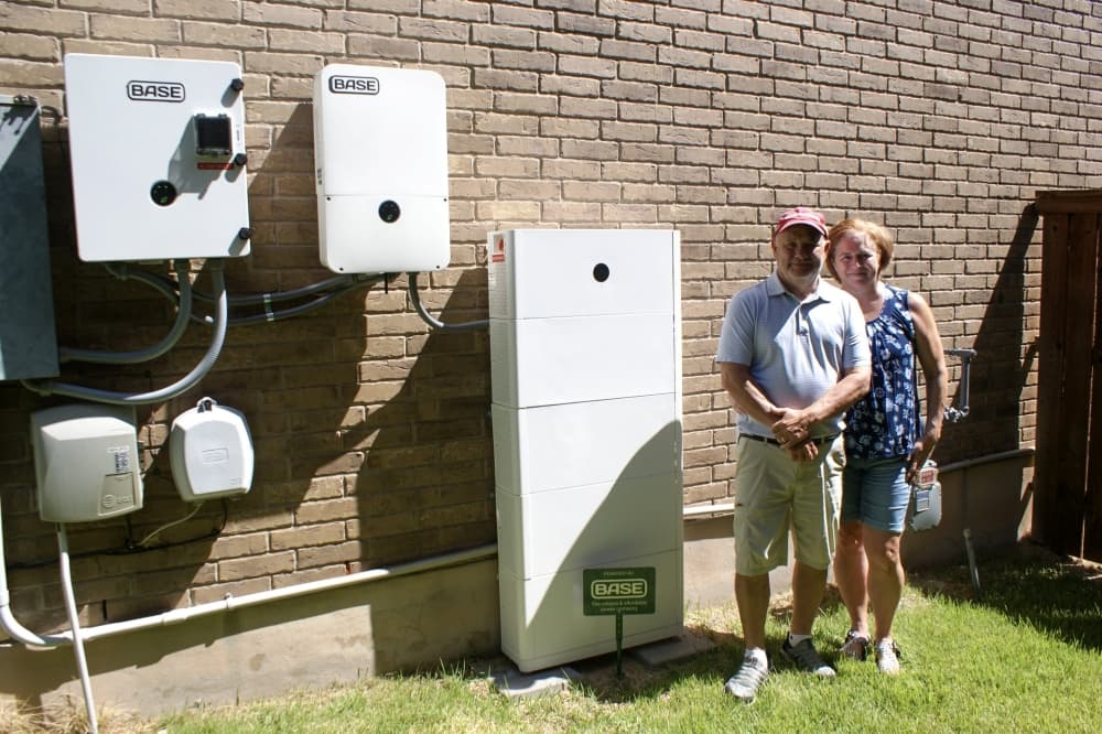 An image of Deborah and Kevin McNair standing with their Base battery setup. 