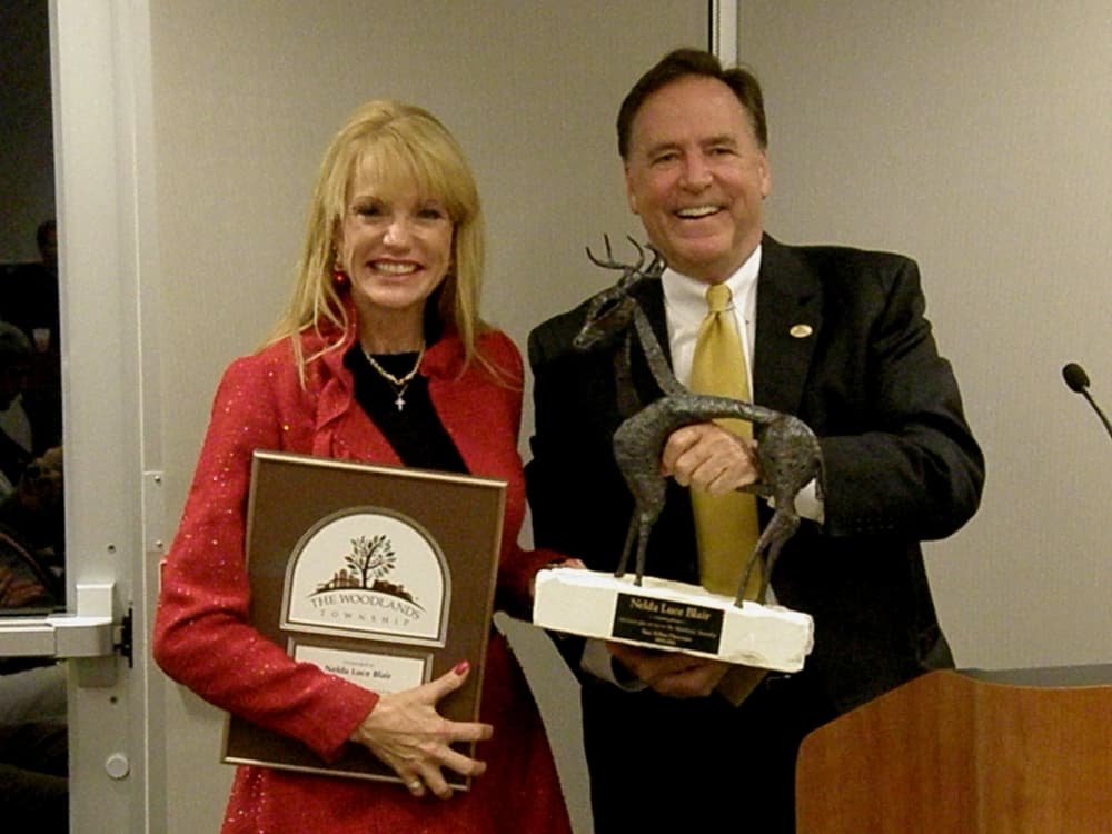 A man and a woman hold plaques.