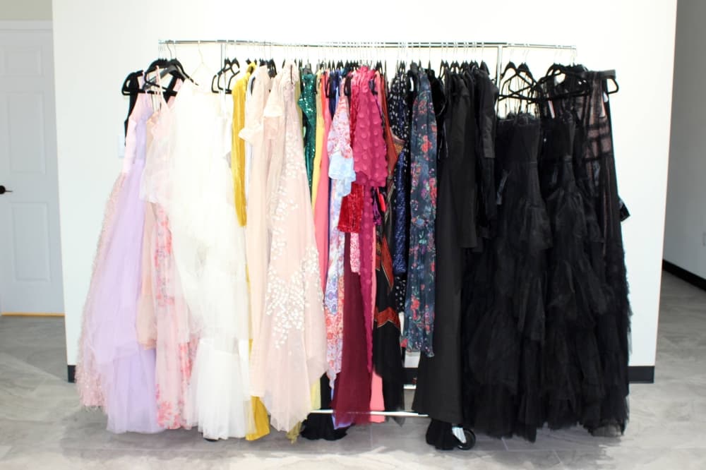 Formal dresses hanging on a rack in a store. 