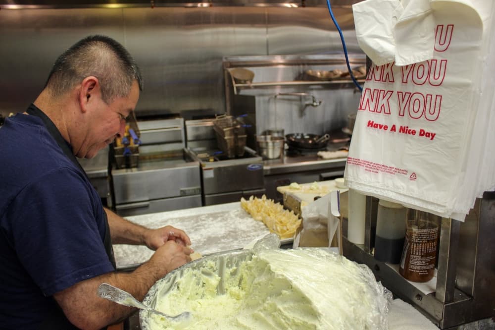 A photo of a chef preparing crab rangoons in the kitchen of the restaurant. 