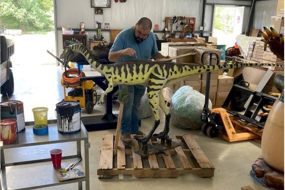 An image of a park employee painting a sculpture. 