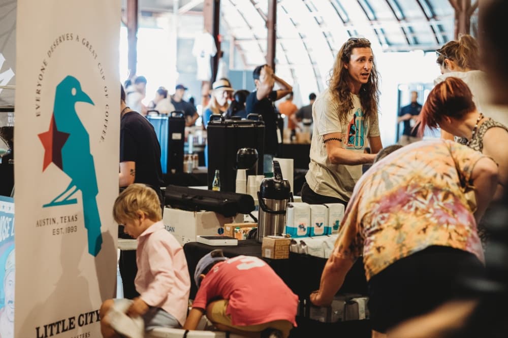 A Little City Coffee Roasters employee speaks with festival attendees at the first Austin Coffee Festival.