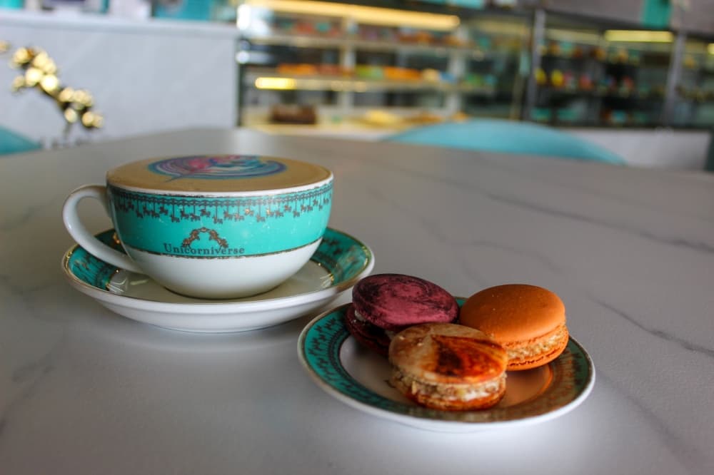 An image of a latte and macarons offered at the bakery. 