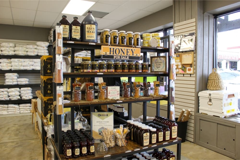An image of a shelf inside the store that has various local honey products. 