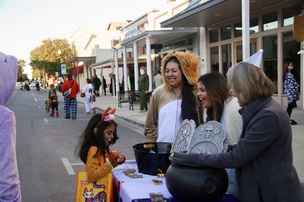 People and children wear costumes downtown.