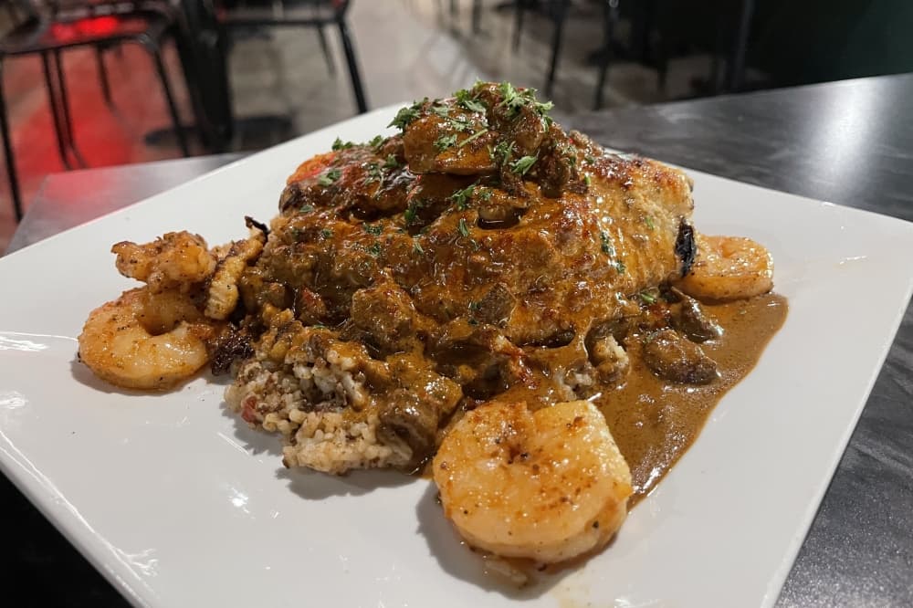 The Dirty South includes blackened catfish, crawfish tails and grilled shrimp over a bed of dirty rice and covered in a dark-roux etouffee sauce. (Grant Crawford/Community Impact)
