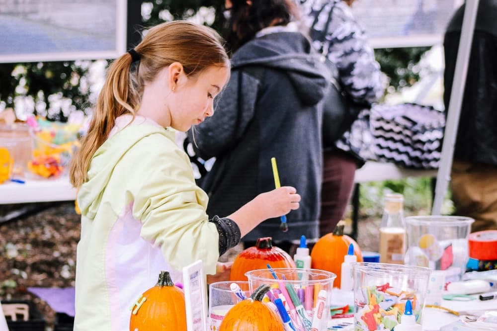 A child paints a pumpkin.