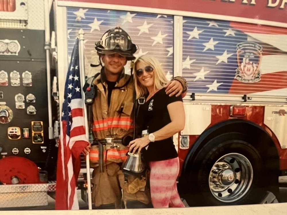 Jorge and Kim Pastore in front of a firetruck