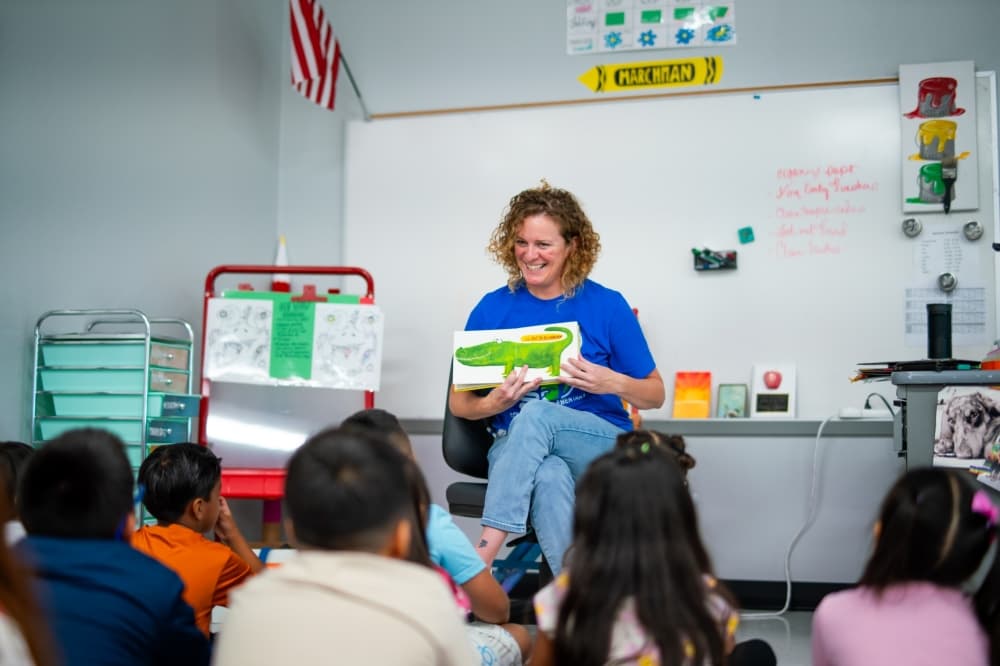 A teacher readers to young students.
