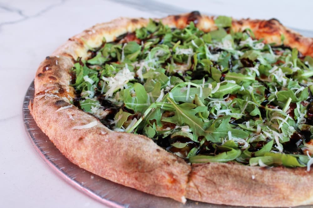Pizza with arugula and balsamic drizzle. 