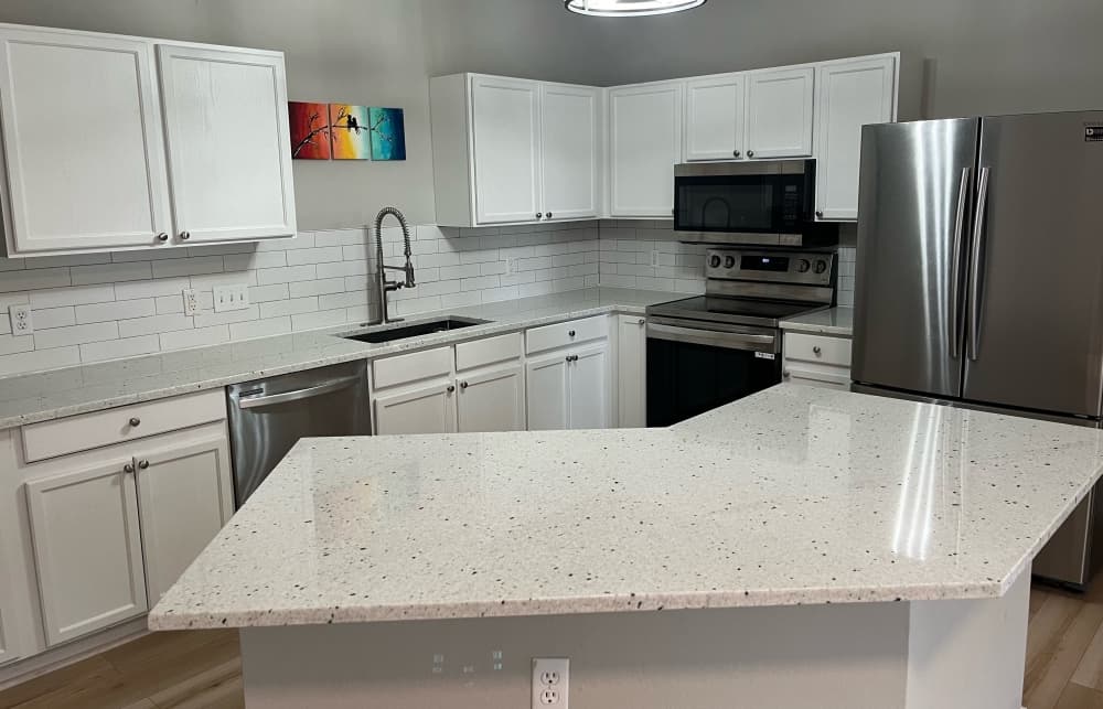 A completed kitchen island with white countertops. 