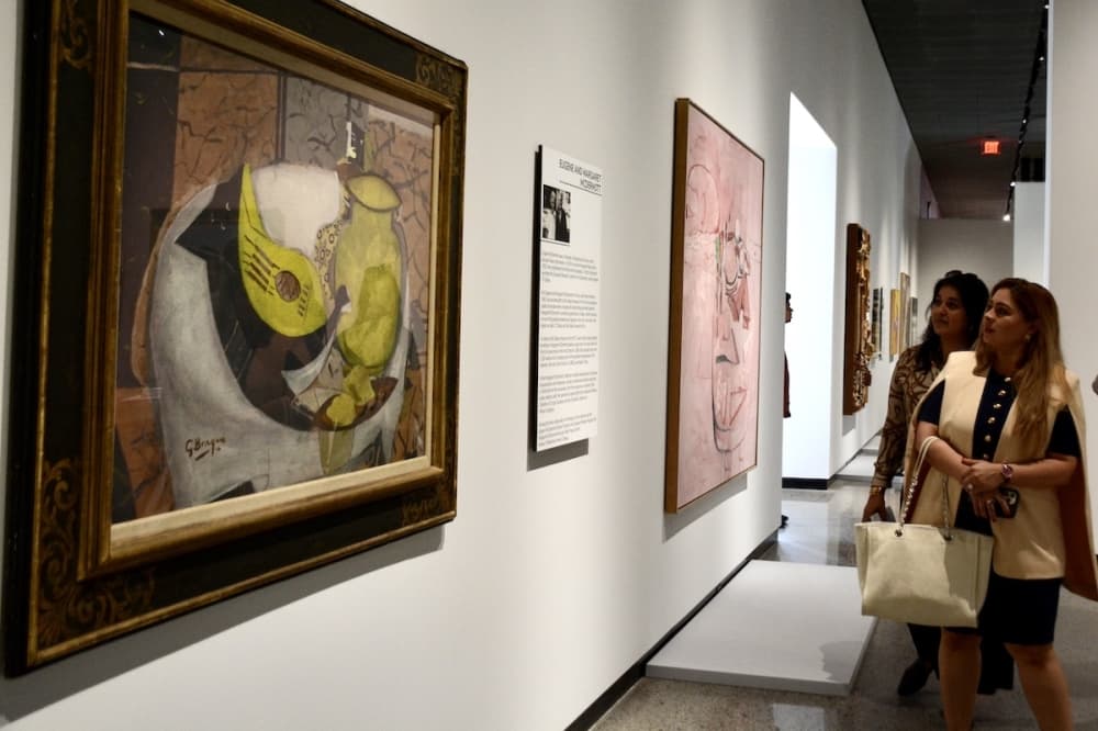 Individuals examine art within the Crow Museum of Asian Art at UT Dallas. 