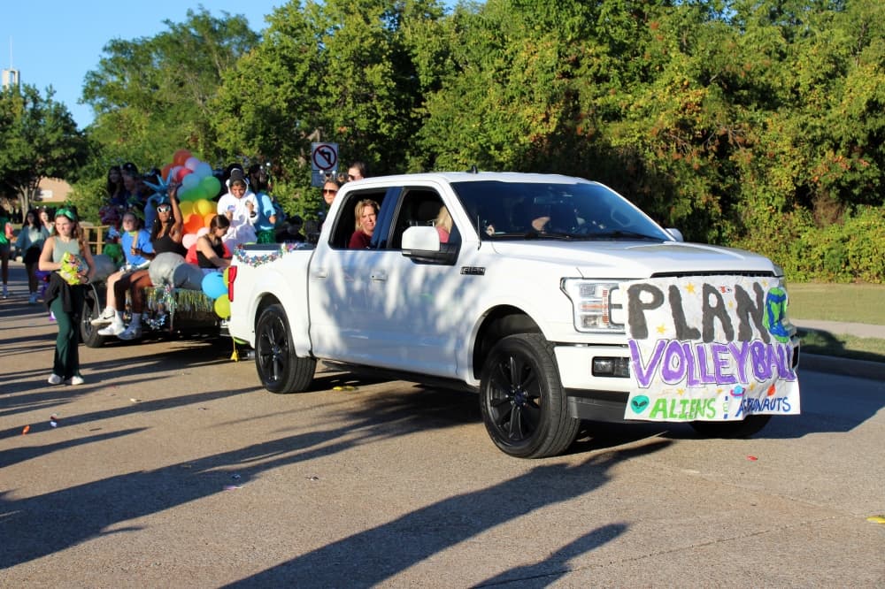 Truck with Plano Volleyball banner on front. 
