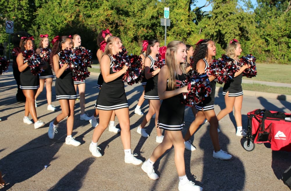 Cheerleaders marching in a parade. 