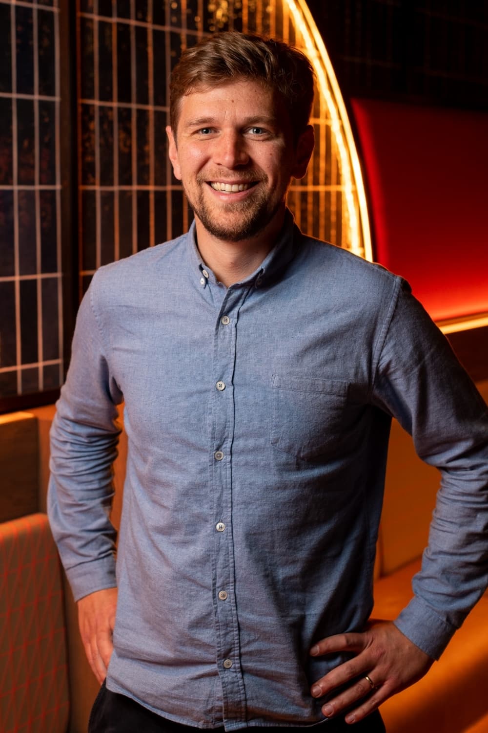 Male, wearing blue button-down, long-sleeved shirt, posing for a picture. 