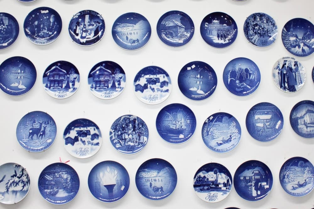 Multiple blue plates hanging on a wall. 