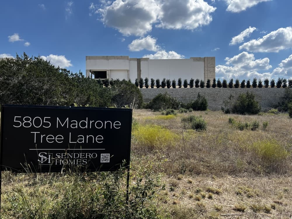 photo of home plot sale sign with west austin business park in near background 