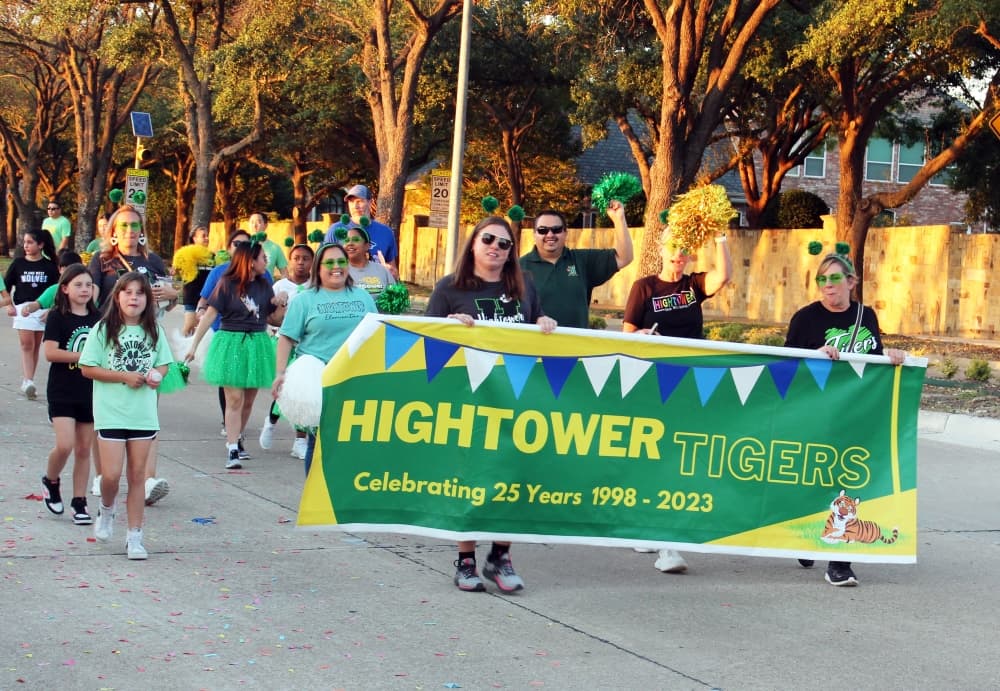 Group in a parade holding green banner. 
