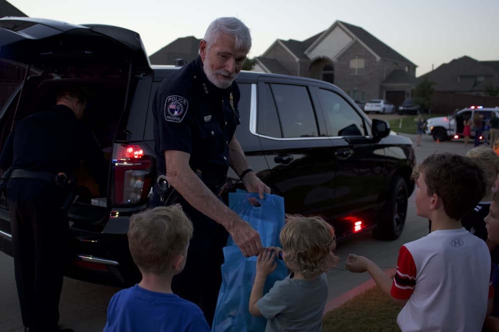 Prosper Police Chief Doug Kowalski hands out stickers and pins. (Alex Reece/Community Impact)