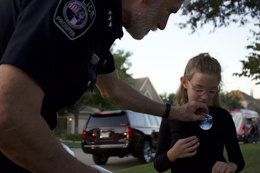 Prosper Police Chief Kowalski places a sticker on a child's shirt. (Alex Reece/Community Impact)