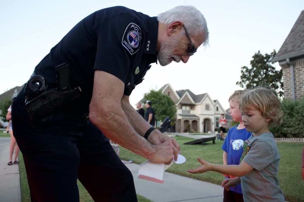 Prosper Police Chief Kowalski hands a sticker to a young resident. (Alex Reece/Community Impact)