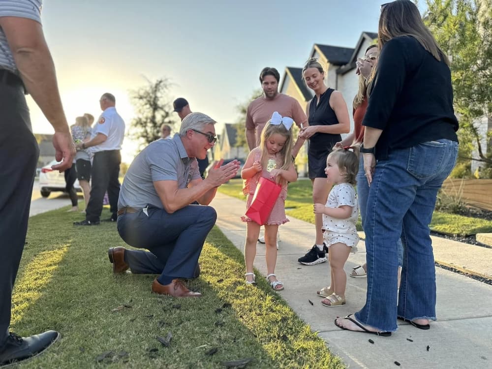 Prosper Mayor David Bristol crouches down during an Oct. 1 block party. (Courtesy town of Prosper)