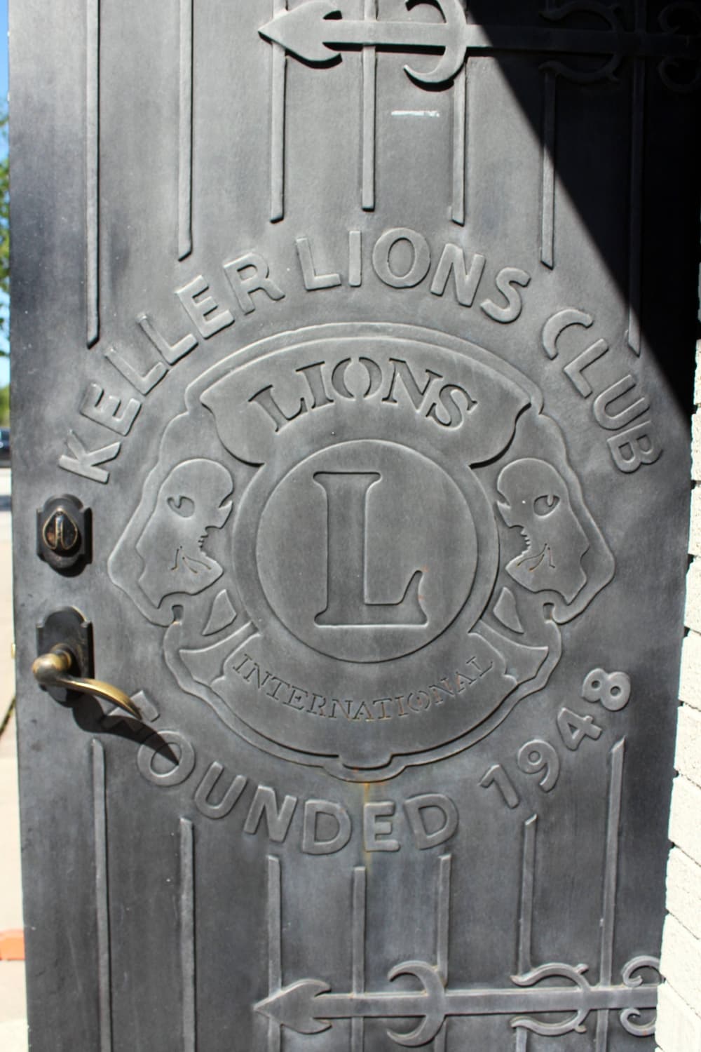Metal door with raised lettering 'Keller Lions Club est. 1948.' and Lions Club logo.