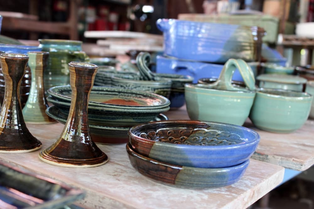 Various pieces of pottery in shades of blue, green and brown. 