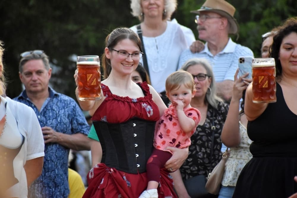 woman holding a baby and a stein