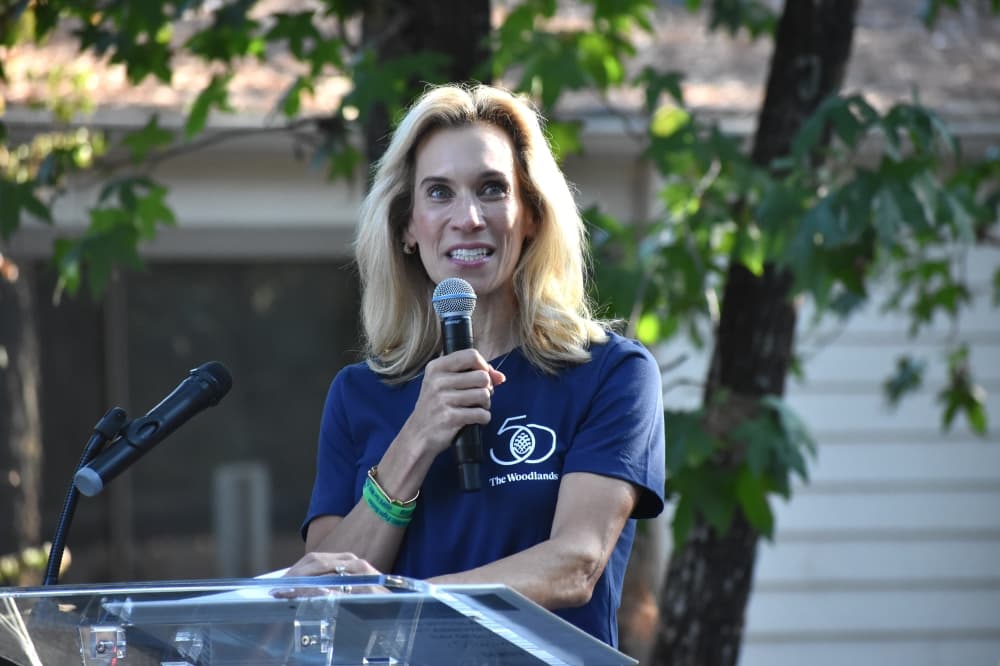 A woman speaks outside at a podium