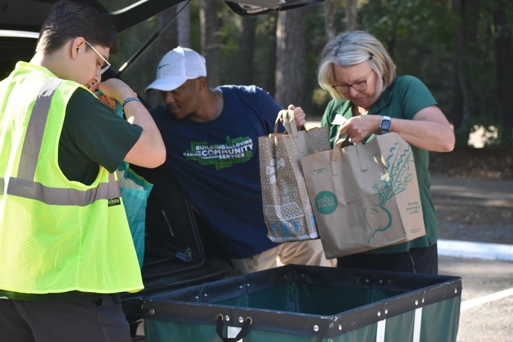 Volunteers unload donations from a car
