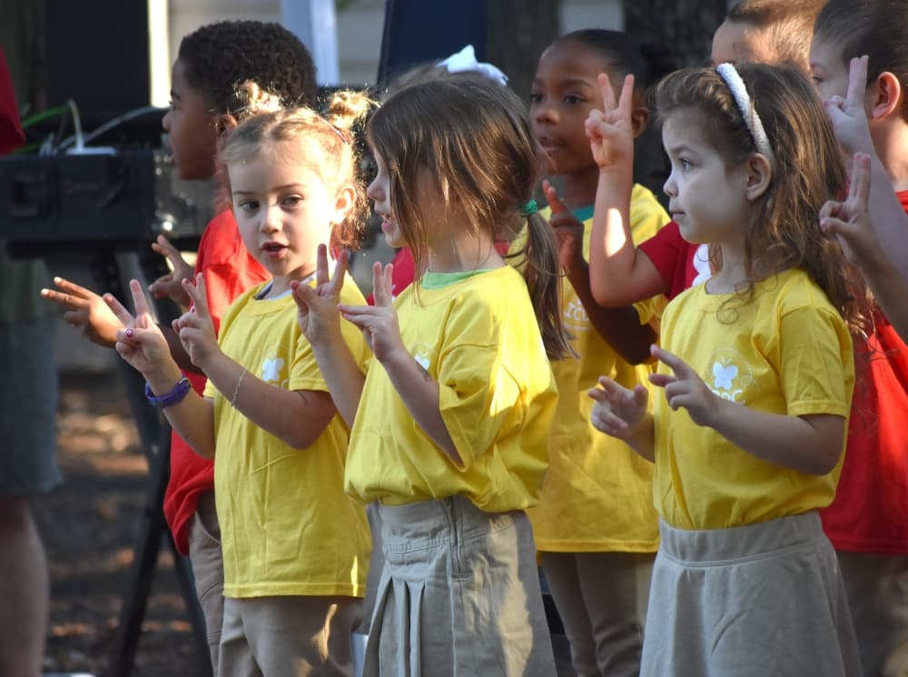 children sing in a group outside