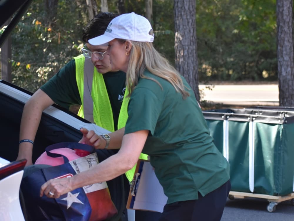 Volunteers unload donations from a car