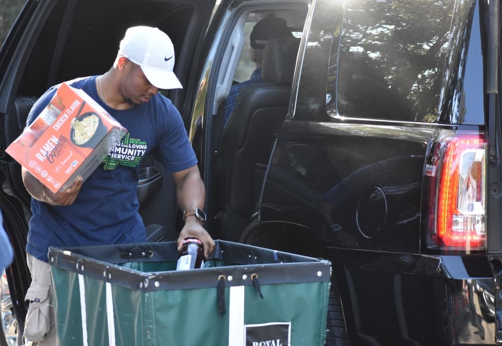 Volunteers unload donations from a car