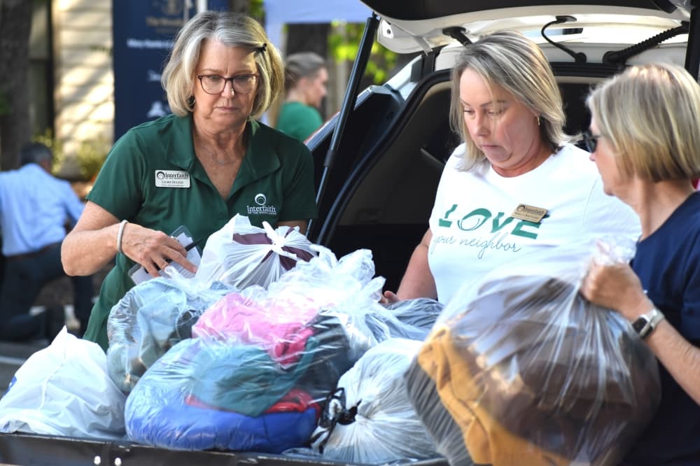 women take bags out of a car