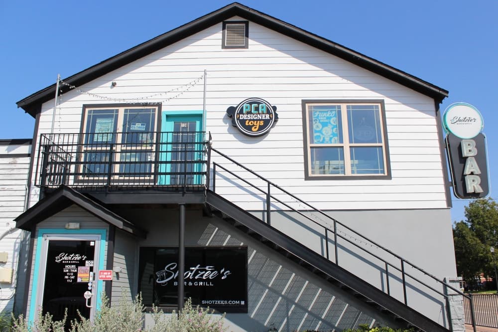 Two-story building with PCA Designer Toys signage. 