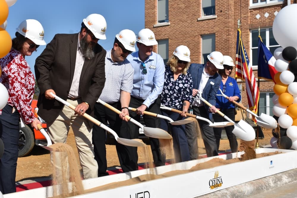 a group of people pick up dirt with shovels