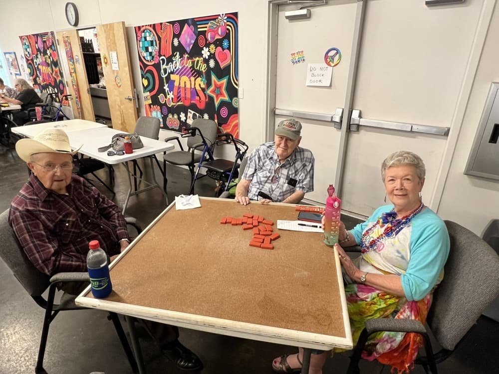 A group of seniors sit at a table and play games during a party.