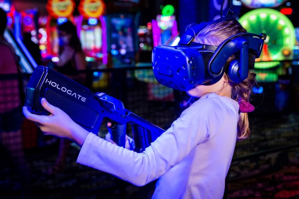 A guest wearing a VR headset and holding a fake gun