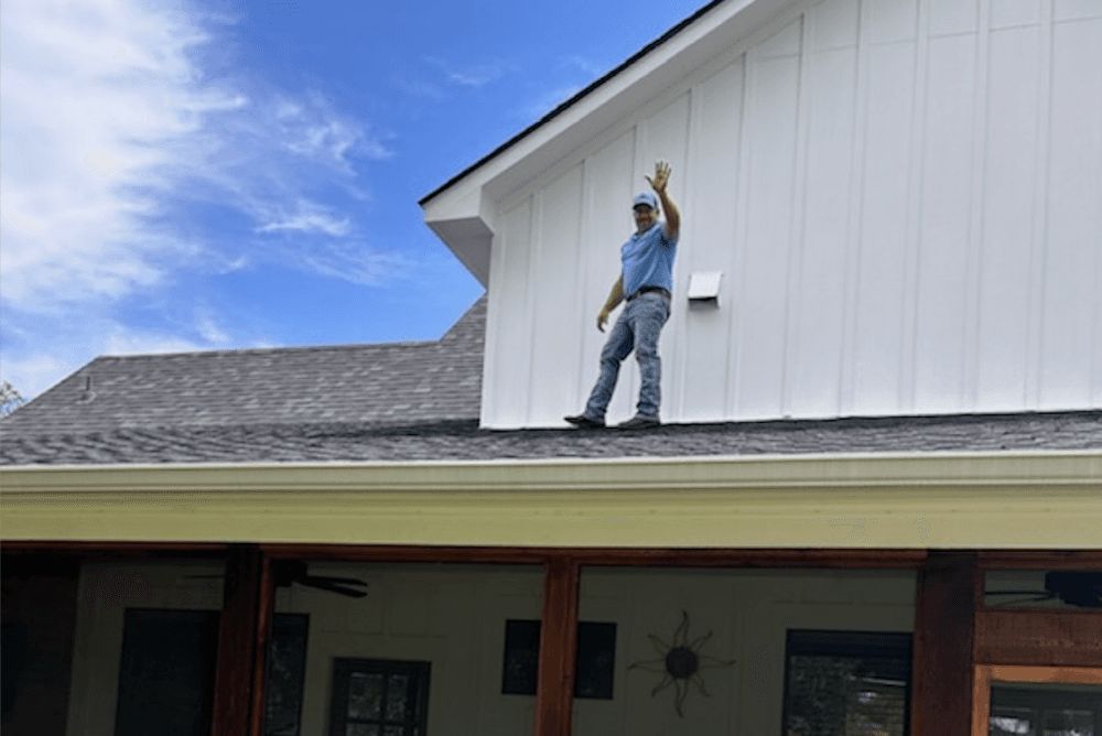 Doug Berryann waves from a rooftop.