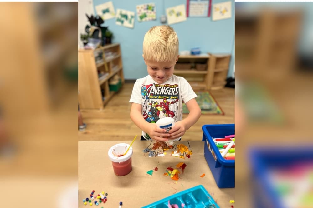 An image of a child playing with glue. 