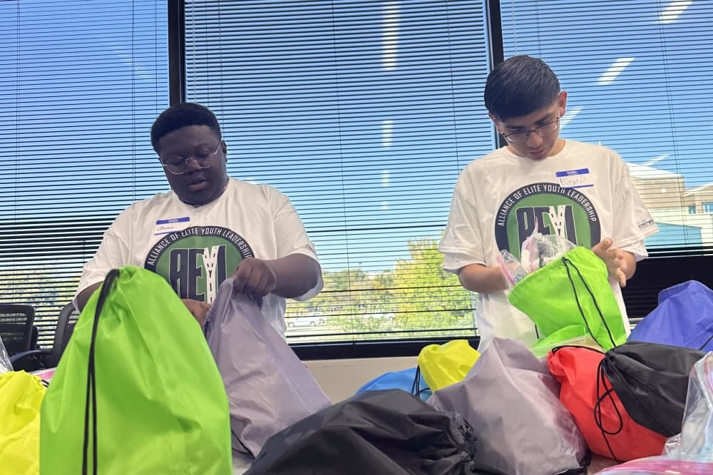 Two teens fill string backpacks 