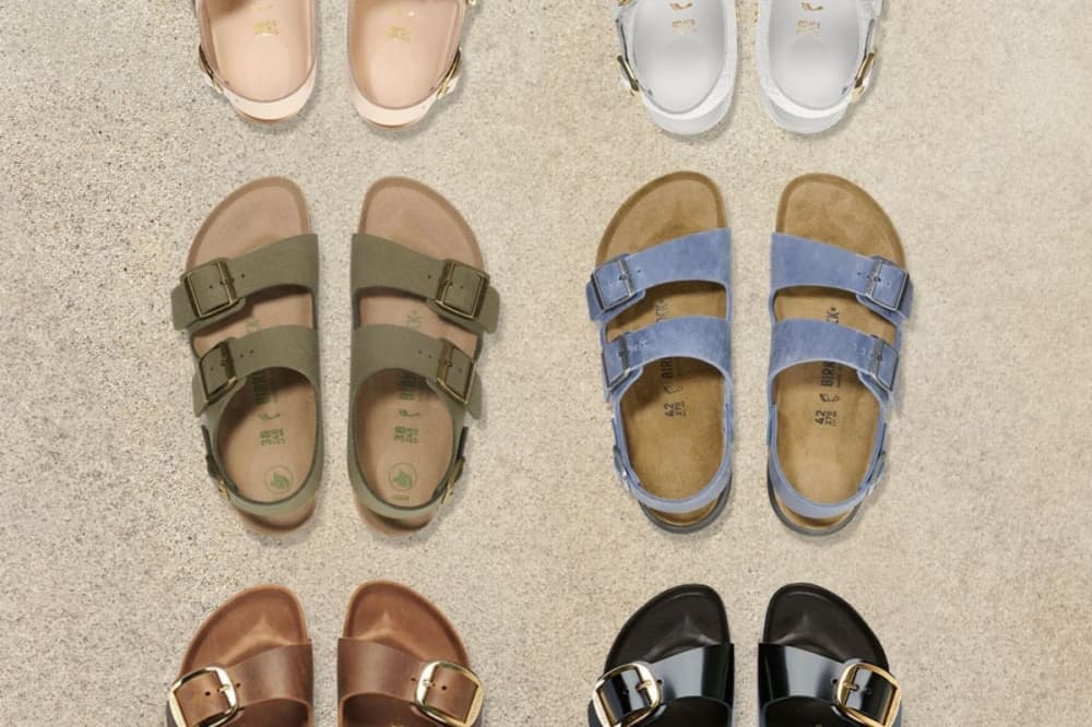 A row of birkenstocks colored peach, white, green, blue, red and black. 