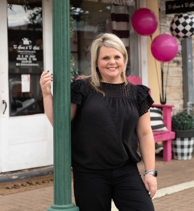 An image of the owner of the business outside the storefront. 