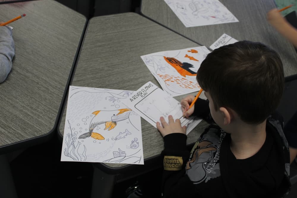 A first grade student designs how a river will flow on a piece of paper during "STEMapalooza" held at Cannon Elementary School on Nov. 1.